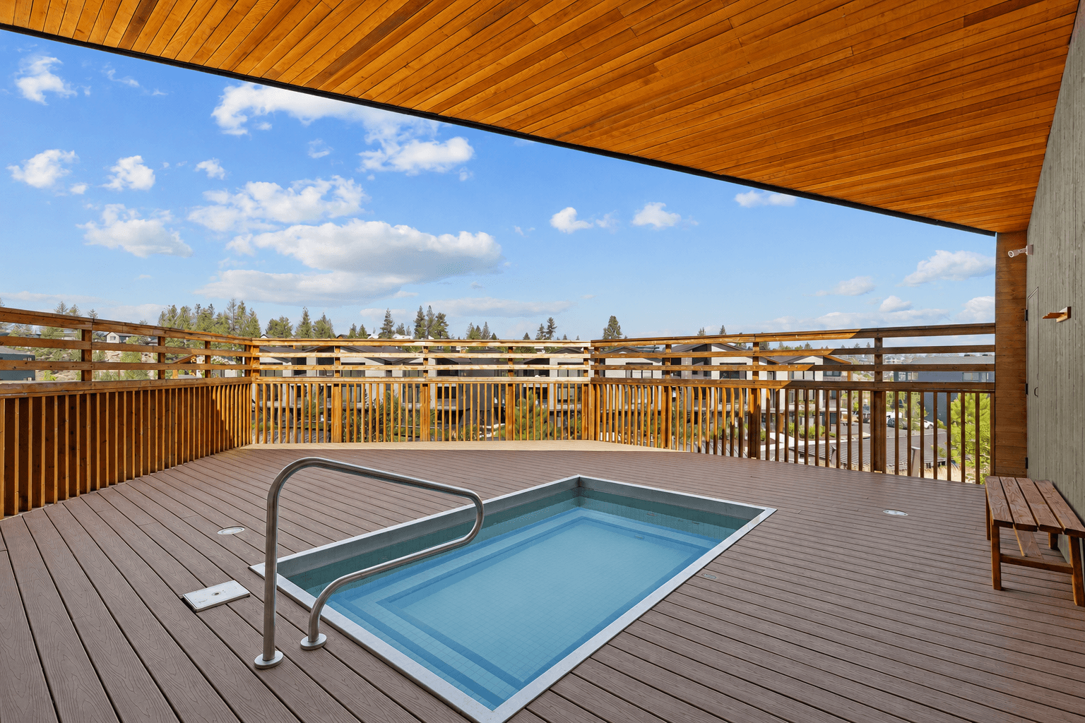 A wooden deck with a pool and bench.,A wooden deck with a pool and bench.